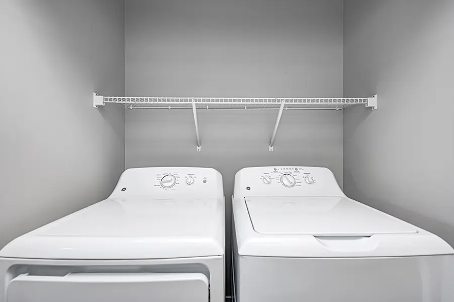 A washer and dryer in an apartment laundry closet
