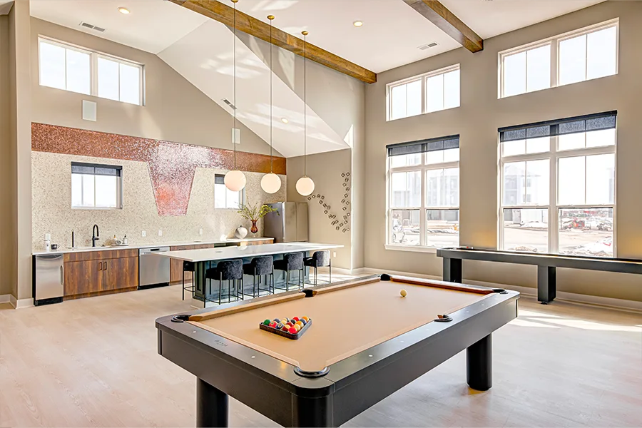 Seating and a pool table inside a stylish apartment clubhouse.